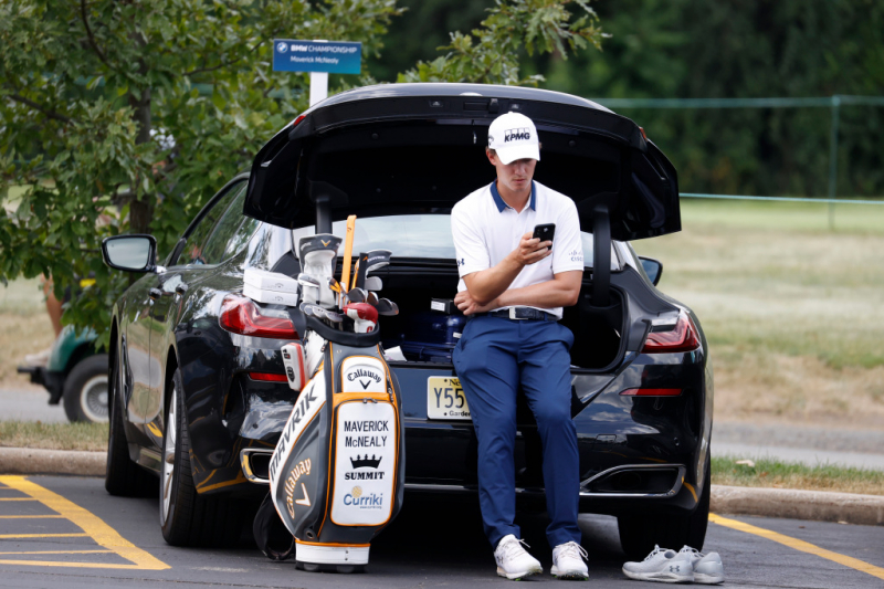 Maverick McNealy kiểm tra điện thoại của mình sau khi kết thúc vòng cuối cùng của giải đấu golf BMW Championship