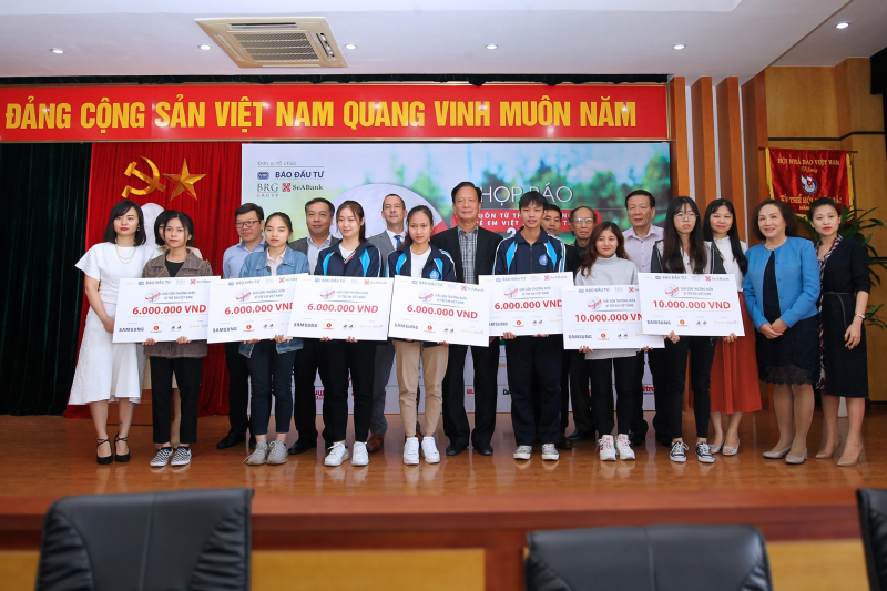 Ban tổ chức, các nhà tài trợ trao học bổng cho 7 sinh viên nghèo vượt khó của Học viện Báo chí - Tuyên truyền và Đại học Sư phạm Hà Nội (Ảnh: Báo Đầu tư)