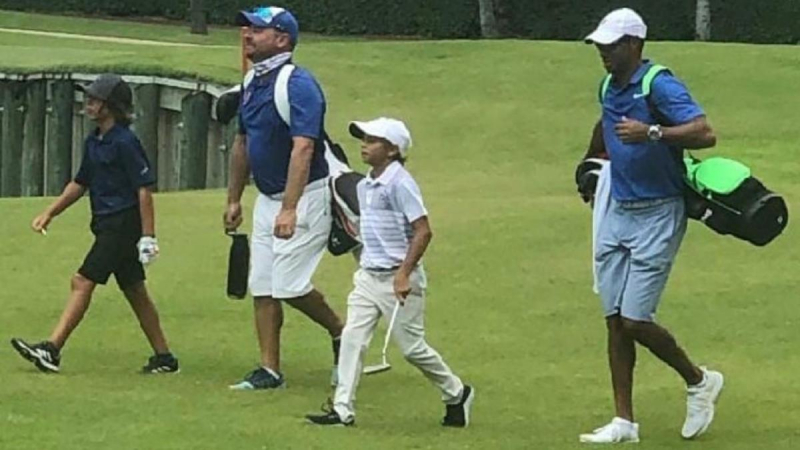 Woods làm caddie cho con trai ở US Kids Golf (Ảnh: CBS Sports)