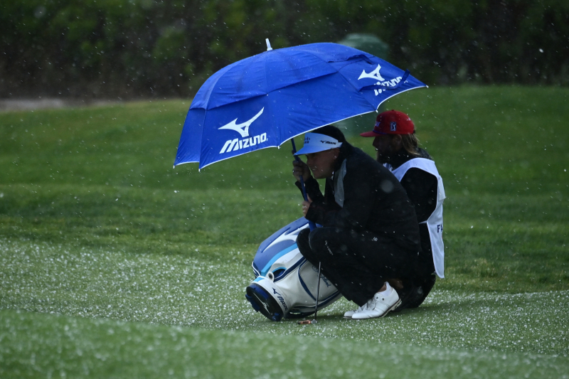 Keith Mitchell với caddie khi một cơn mưa đá ập đến sân ở vòng hai (Ảnh: Donald Miralle/Getty Images)