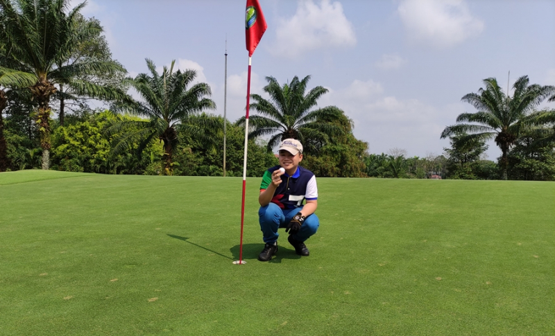 Tay golf trẻ Quốc Trung cùng trái bóng ghi HIO tại sân golf Long Thành (Ảnh: Caddies Việt Nam)