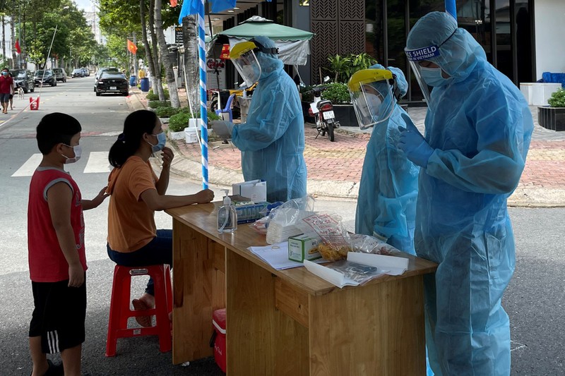 Ngành y tế tỉnh Bình Dương tiến hành lấy mẫu xét nghiệm người dân tại địa điểm bị phong tỏa. (Ảnh: Lê Ánh/PLO)