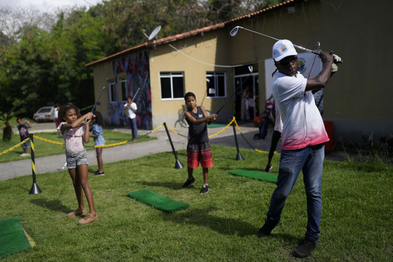 Marcelo Modesto (bìa phải) đang hướng dẫn golf cho trẻ em khu ổ chuột tại trung tâm văn hoá Nusacquilombo, Cidade de Deus ở Rio