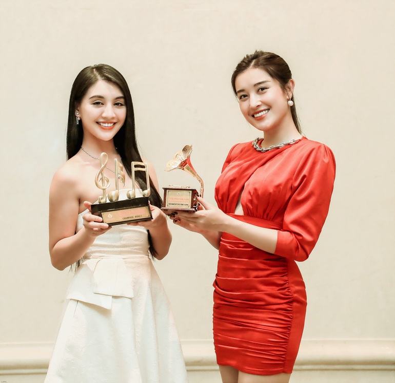 Á hậu Huyền My (trái) và Người đẹp áo dài Thanh Tú nhận cúp được thiết kế độc đáo liên quan đến âm nhạc tại giải đấu hôm 22/1
