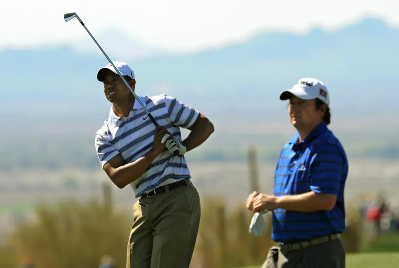 Tim Clark của Nam Phi theo dõi tay golf số một thế giới Tiger Woods thực hiện cú đánh trong giải Accenture Match Play Championship được tổ chức tại Câu lạc bộ Golf Ritz-Carlton, sân Dove Mountain ở Tucson, Arizona vào ngày 26 tháng 2 năm 2009. (Ảnh: MARK RALSTON/AFP qua Getty Images)