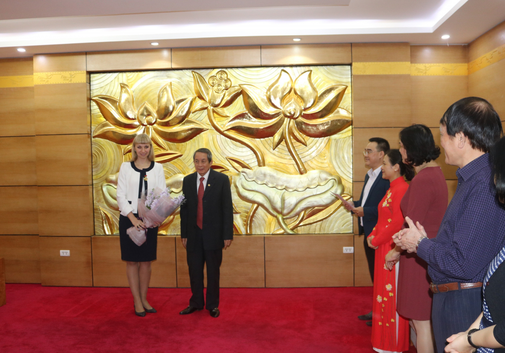 Ông Trần Đình Long, Phó Chủ tịch Hội Hữu nghị Việt - Nga, tặng hoa chúc mừng bà N. Shafinskaya được tặng Kỷ niệm chương của Liên hiệp các tổ chức hữu nghị Việt Nam.  Ảnh: XUÂN HƯNG