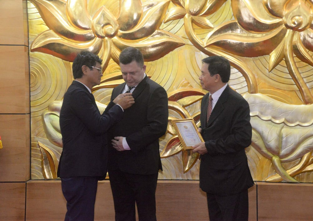 Ông Trần Bình Minh - Chủ tịch Hội Hữu nghị Việt-Nga - trao Kỷ niệm chương tặng một cán bộ ĐSQ Nga. Ảnh: VŨ HUYẾN