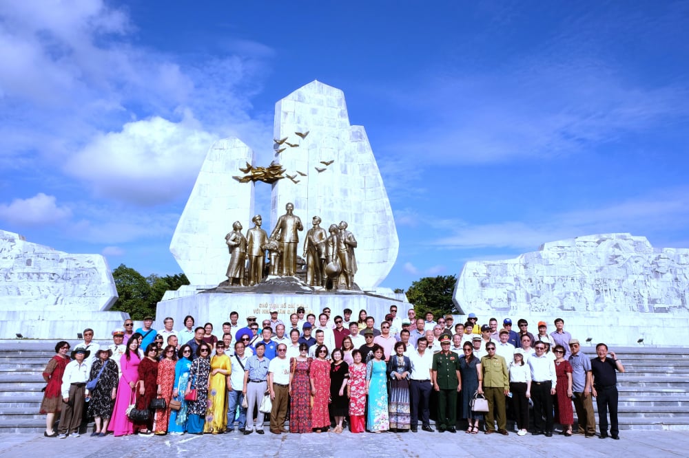 Các đại biểu chụp ảnh lưu niệm trước tượng đài Chủ tịch Hồ Chí Minh và tỉnh Quảng Bình tại Quảng trường trung tâm TP Đồng Hới  Ảnh: PHẠM TIẾN DŨNG