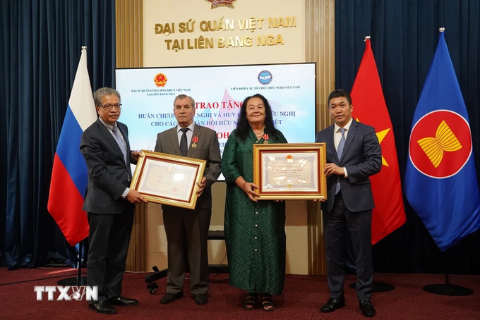 Đại sứ Đặng Minh Khôi (bìa trái) và Chủ tịch Liên hiệp các TCHNVN Phan Anh Sơn (bìa phải) trao Huân chương Hữu nghị tặng hai cán bộ Hội Hữu nghị Nga - Việt