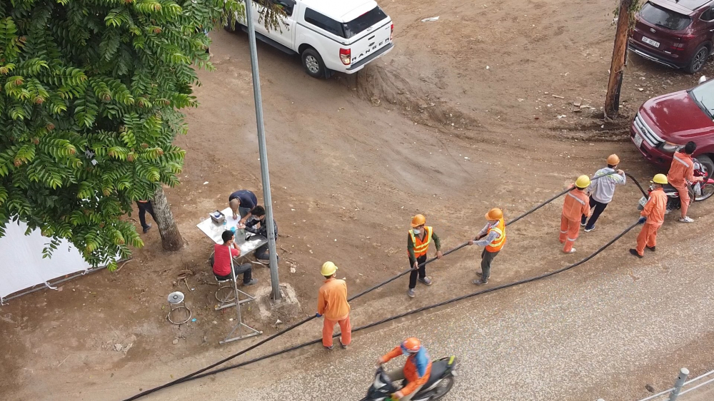 Công nhân của Công ty Điện lực Hoàng Mai đang khẩn trương kéo đường điện để đấu nối và thi công nguồn cấp điện