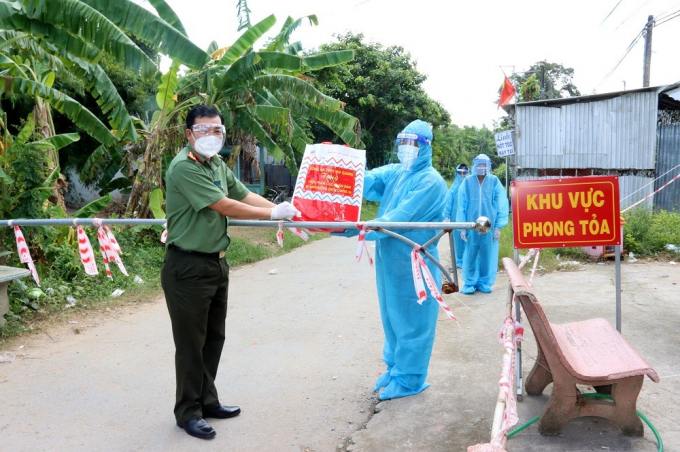 Đại tá Lâm Thành Sol, Phó Giám đốc Công an tỉnh An Giang trao quà cho người dân trong khu vực phong tỏa tại tỉnh Trà Vinh