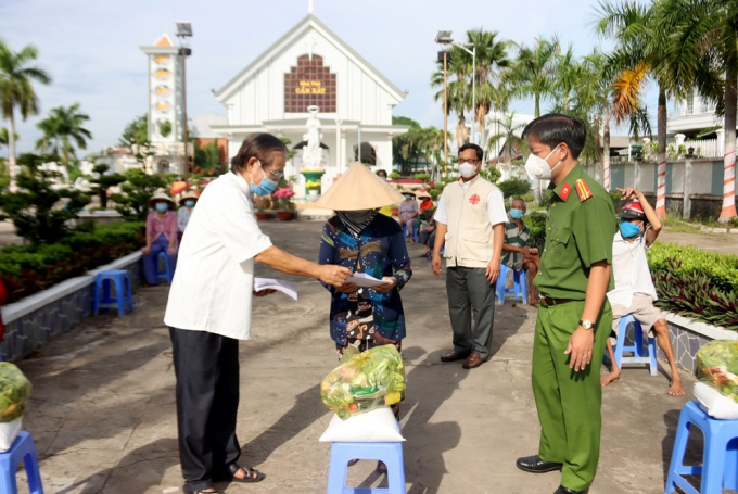 Trung tá Nguyễn Đức Hậu, Trưởng Công an TP. Long Xuyên cùng Linh mục Trần Văn Khoa, Chánh xứ Giáo xứ Cần Xây tặng quà cho bà con giáo dân tại phường Bình Đức