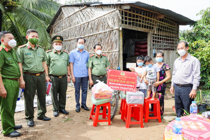 Thiếu tướng Nguyễn Văn Thuận (thứ 5 từ trái qua) trao tặng quà gia đình 2 cháu Nguyễn Huỳnh Thế Vinh và Nguyễn Huỳnh Gia Bảo.​