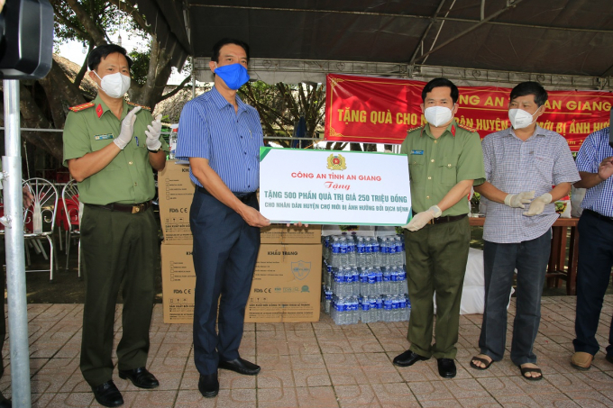 Đại tá Đinh Văn Nơi, Giám đốc Công an tỉnh và Đại tá Nguyễn Nhật Trường, Phó Giám đốc Công an tỉnh trao bảng tượng trưng các phần quà hỗ trợ người dân huyện Chợ Mới.