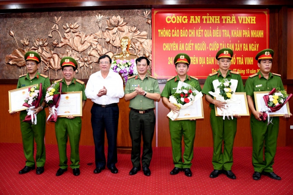 Ông Lê Văn Hẳn, Chủ tịch Ủy ban nhân dân tỉnh và Đại tá Trần Xuân Ánh, Giám đốc Công an tỉnh trao bằng khen và tặng hoa cho các cá nhân có thành tích xuất sắc trong điều tra khám phá án. Ảnh: Công an Trà Vinh.