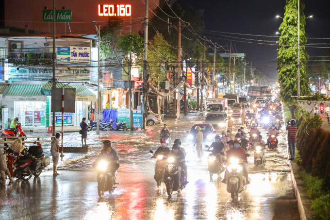 Tuyến đường Nguyễn Văn Cừ nối dài, đoạn dưới chân cầu Rạch Ngỗng 2, các phương tiện di chuyển nối đuôi nhau qua đoạn ngập sâu.