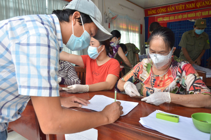 Người dân phường An Hòa, thành phố Rạch Giá, nhận tiền hỗ trợ khó khăn do đại dịch Covid-19 theo Nghị quyết số 68/NQ-CP của Chính phủ. Ảnh: Mi Ni