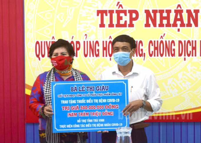 Tiếp nhận hàng hóa do bà Lê Thị Giàu đại diện Công ty Cổ phần Thực phẩm Bình Tây trao tặng. Ảnh: BáoTrà Vinh.