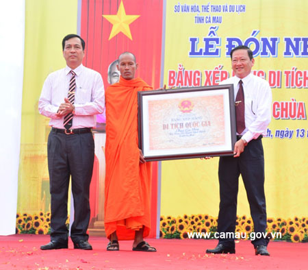 Phó Chủ tịch UBND tỉnh Trần Hồng Quân (bìa trái) trao Bằng xếp hạng Di tích quốc gia của Bộ Văn hoá, Thể thao và Du lịch cho Chùa Cao Dân. Ảnh: camau.gov