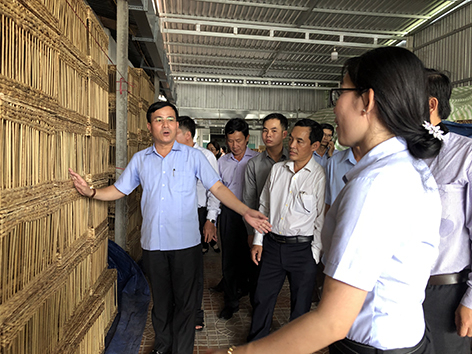 Ông Trần Văn Huyến (bìa trái), Phó Bí thư Thường trực Tỉnh ủy, Chủ tịch HĐND tỉnh, đến thăm Tổ hợp tác Nhựt Linh chuyên sản xuất các mặt hàng thủ công mỹ nghệ do bà Loan làm Tổ trưởng (ảnh tư liệu).