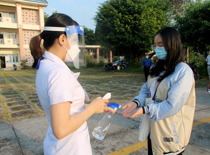 Học sinh đo thân nhiệt, rửa tay sát khuẩn trước khi vào lớp. Ảnh: dongthapgov.