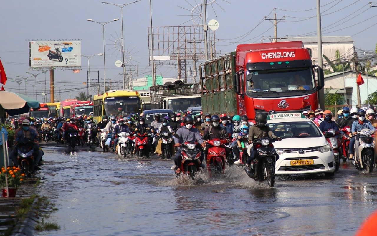 Ảnh hưởng triều cường khiến lòng đường quốc lộ 1A (đoạn thuộc địa phận tỉnh Vĩnh Long) bị thu hẹp, hàng nghìn phương tiện di chuyển khá chậm. Ảnh: QUỐC AN.