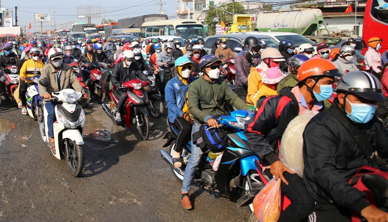 Nhiều phương tiện mô tô, ô tô “chôn chân” giữa biển người trên quốc lộ 1A, đoạn địa phận tỉnh Vĩnh Long. Ảnh: QUỐC AN.