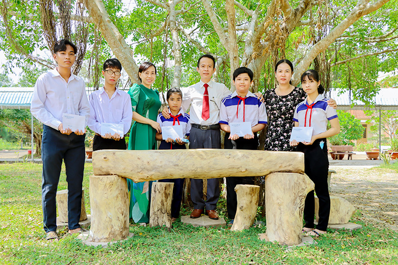 Thầy Lê Quốc Trung (thứ tư, từ phải qua) - Hiệu trưởng Trường Trung học cơ sở và Trung học phổ thông Mong Thọ (Châu Thành) tặng quà tết cho học sinh nghèo, học sinh có hoàn cảnh khó khăn dịp Tết Nguyên đán Nhâm Dần năm 2022.