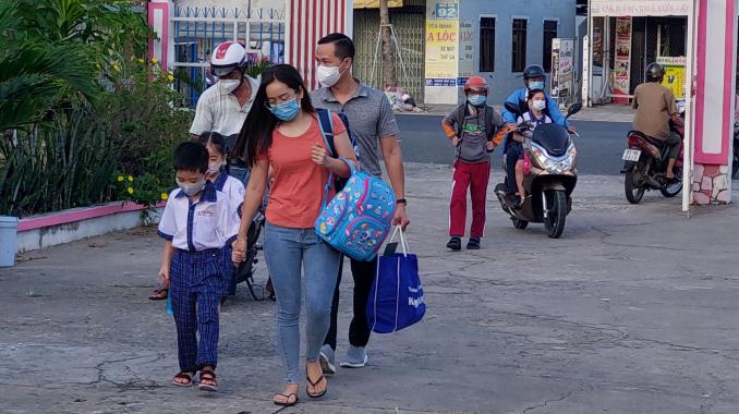 Các em học sinh trở lại trường.