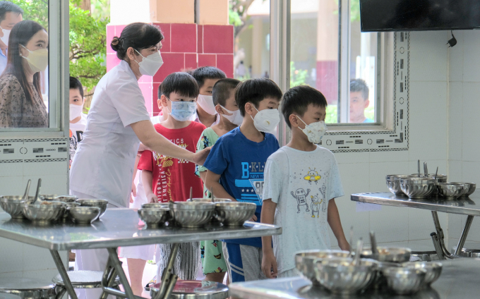 Các em học sinh đến bếp ăn để ăn bửa trưa trong ngày học bán trú đầu tiên.