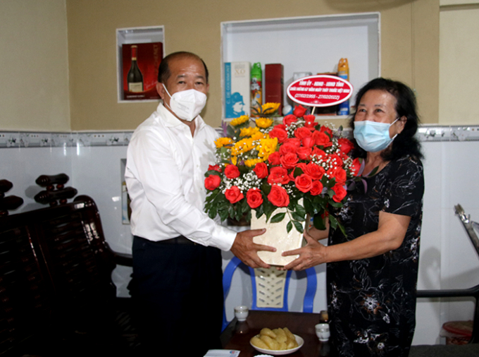 Phó Chủ tịch Uỷ ban nhân dân tỉnh tặng hoa chúc mừng Thầy thuốc ưu tú Trần Thị Năm, nguyên Phó Giám đốc Sở Y tế. Ảnh: dongthapgov.