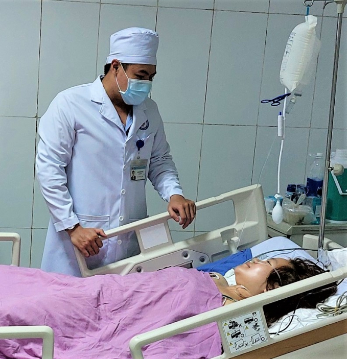 Bác sĩ Nguyễn Bình Phong đang thăm khám cho một bệnh nhân đang điều trị.