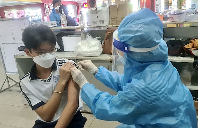 Nhân viên y tế thành phố Rạch Giá tiêm vắc-xin phòng Covid-19 cho học sinh Trường trung học cơ sở Nguyễn Du. Ảnh: Tỉnh ủy Kiên Giang.