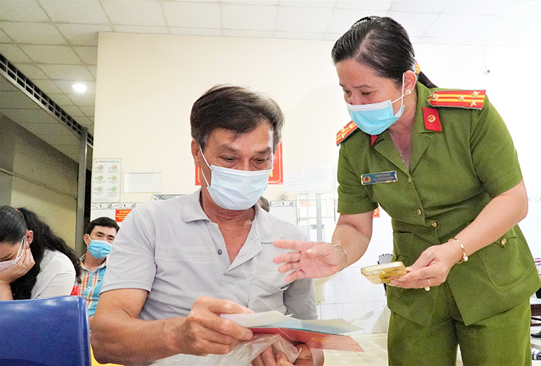 Thượng tá Phạm Thị Cúc hướng dẫn người dân thực hiện thủ tục làm căn cước công dân.