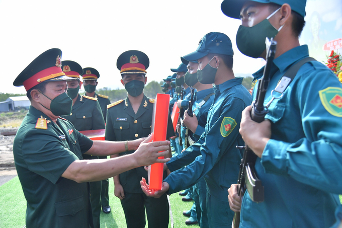 Đại tá Nguyễn Văn Ngành - Chỉ huy trưởng Bộ Chỉ huy Quân sự tỉnh trao quốc kỳ và cờ dân quân tự vệ cho các thuyền trưởng Hải đội dân quân thường trực tỉnh.