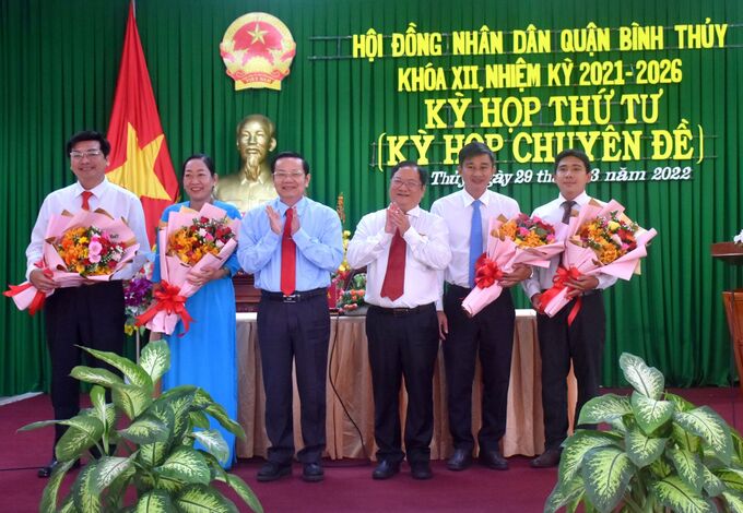 Ông Nguyễn Thành Đông, Phó Chủ tịch HĐND TP Cần Thơ tặng hoa chúc mừng các đồng chí vừa được bầu giữ chức danh Chủ tịch, Phó Chủ tịch và Ủy viên UBND quận Bình Thủy.