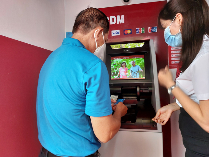Khách hàng sử dụng máy ATM tự động.