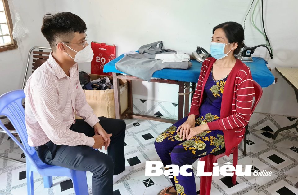 Cán bộ tín dụng Ngân hàng CSXH thăm hỏi tình hình việc học của con chị Nguyễn Thị Nga.