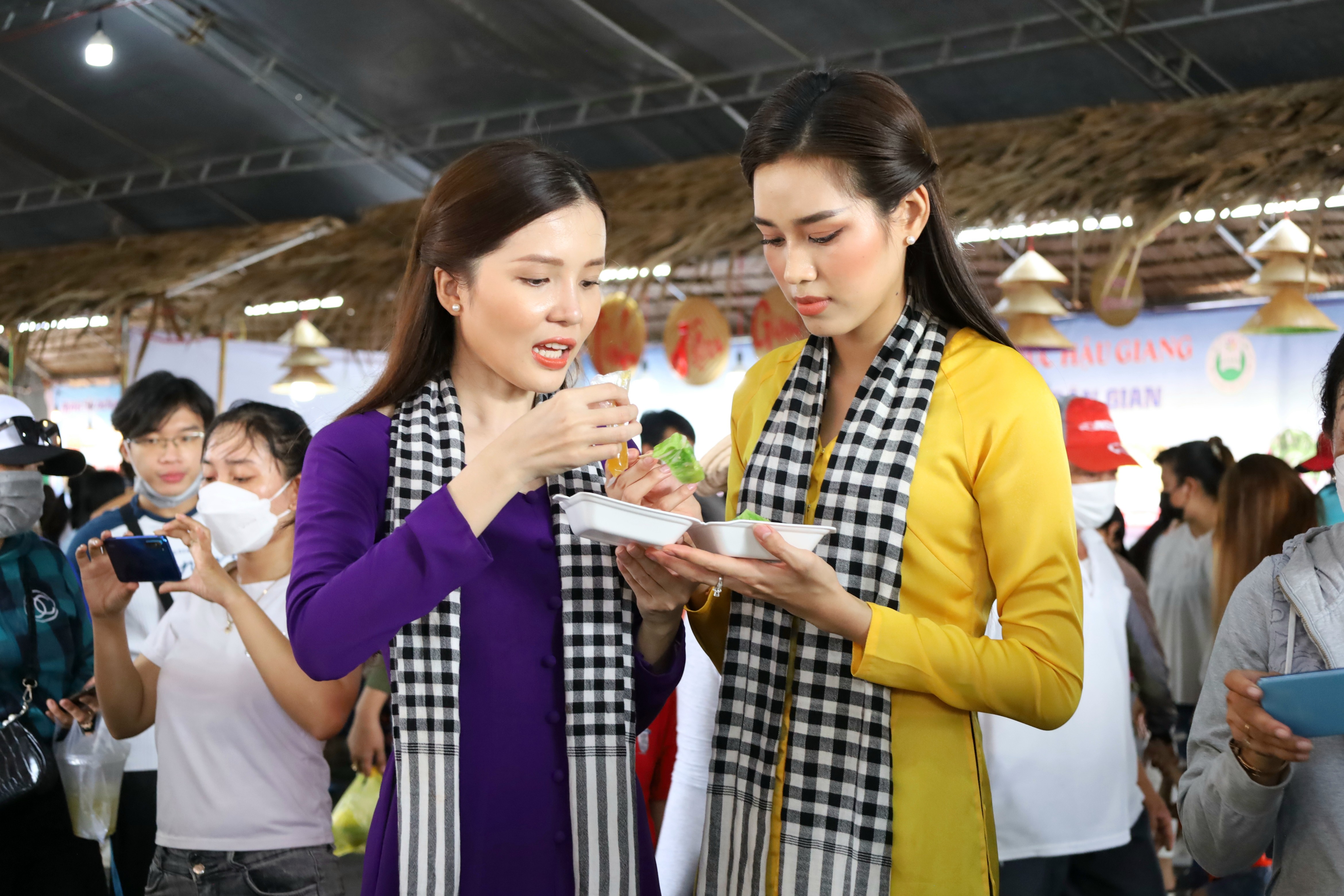 Hoa hậu Đỗ Thị Hà và Hoa khôi Huỳnh Thuý Vi cùng nhau thưởng thức bánh dân gian Nam Bộ.