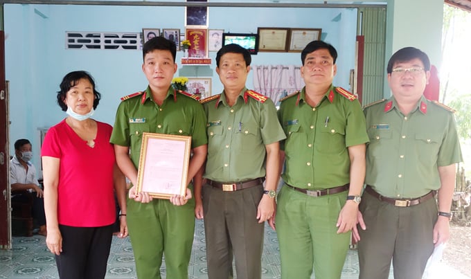 Đại tá Nguyễn Nhật Trường, Phó Giám đốc Công an tỉnh (đứng giữa) trao nhà cho Thượng sĩ Hồ Chiến Đấu.