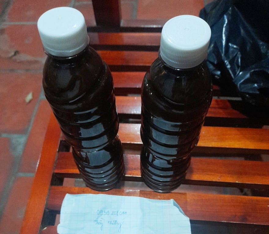 Hai chai nước màu đen, không nhãn mác được vợ chồng “thầy” Khương giới thiệu là thuốc gia truyền bán với giá 300.000 đồng.
