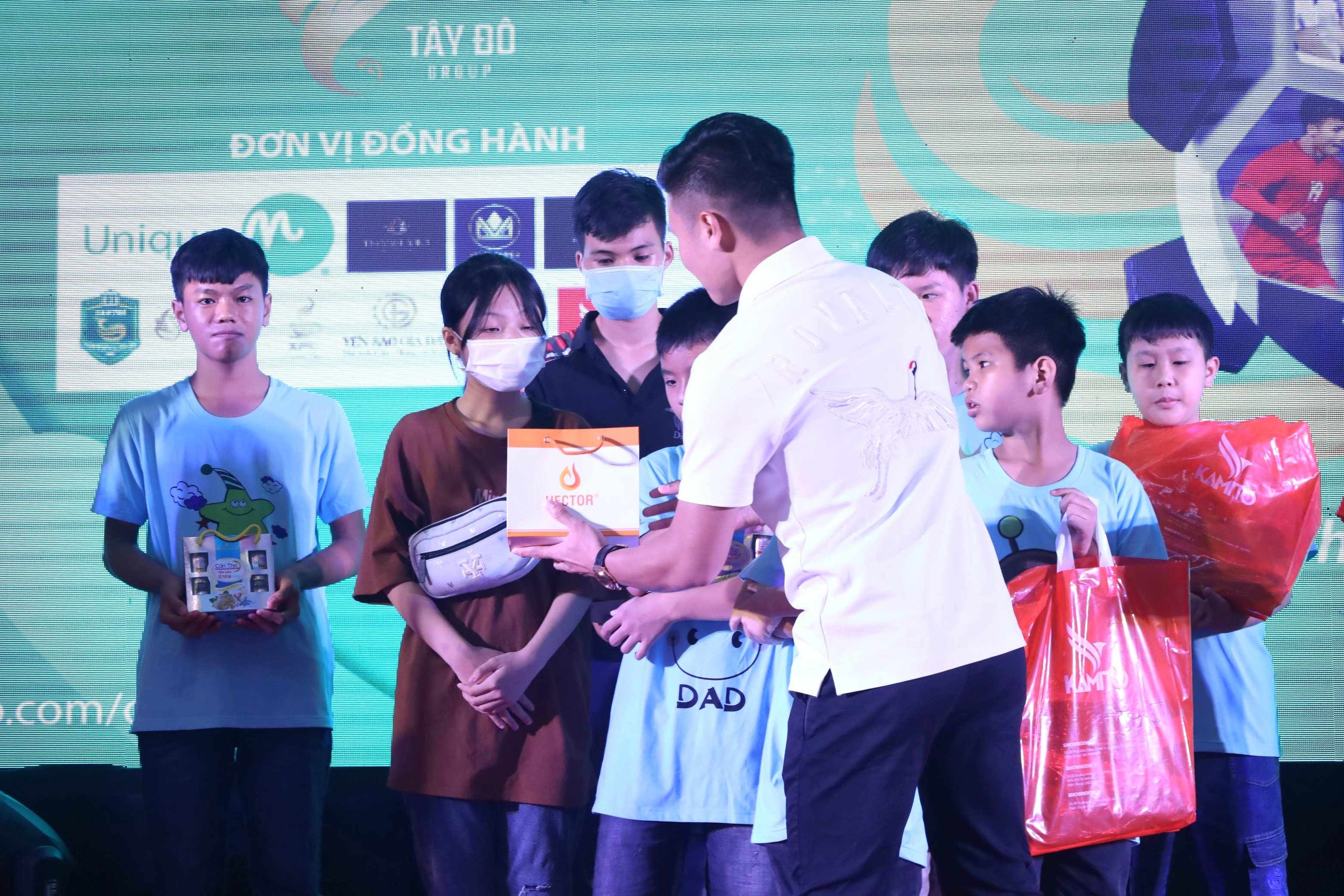 Tuyển thủ Quang Hải tặng quà cho các em học sinh.