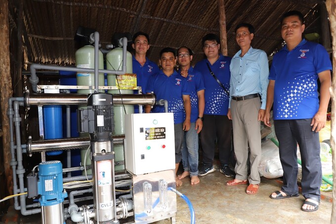 Các thành viên tham gia lắp đặt hệ thống lọc nước chụp ảnh lưu niệm cùng đại diện Công đoàn Tổng công ty Phát điện 2 và chính quyền địa phương.
