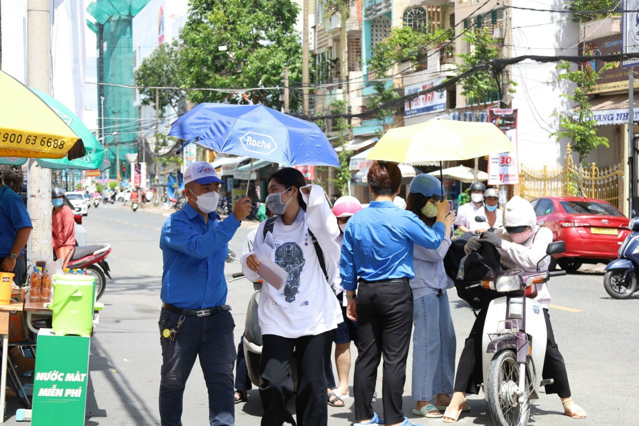 Khi thời tiết nắng nóng các bạn tình nguyện viên che dù cho thí sinh tránh nắng nóng ảnh hưởng sức khỏe.