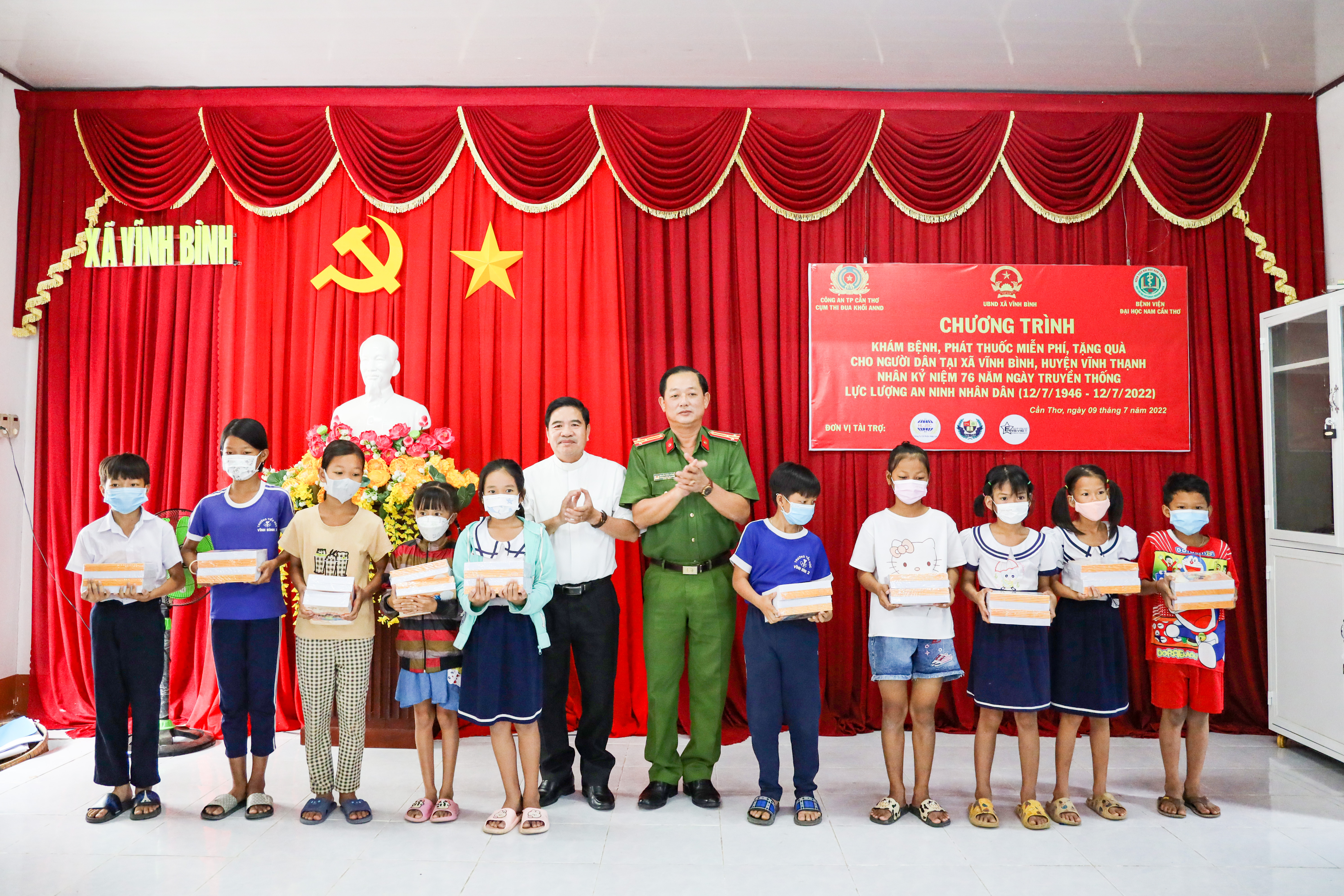 Thượng tá Nguyễn Phúc Cường - Trưởng Công an huyện Vĩnh Thạnh và ông Đỗ Minh Hiến - Chánh xứ Sáu Bọng trao quà cho các em học sinh.