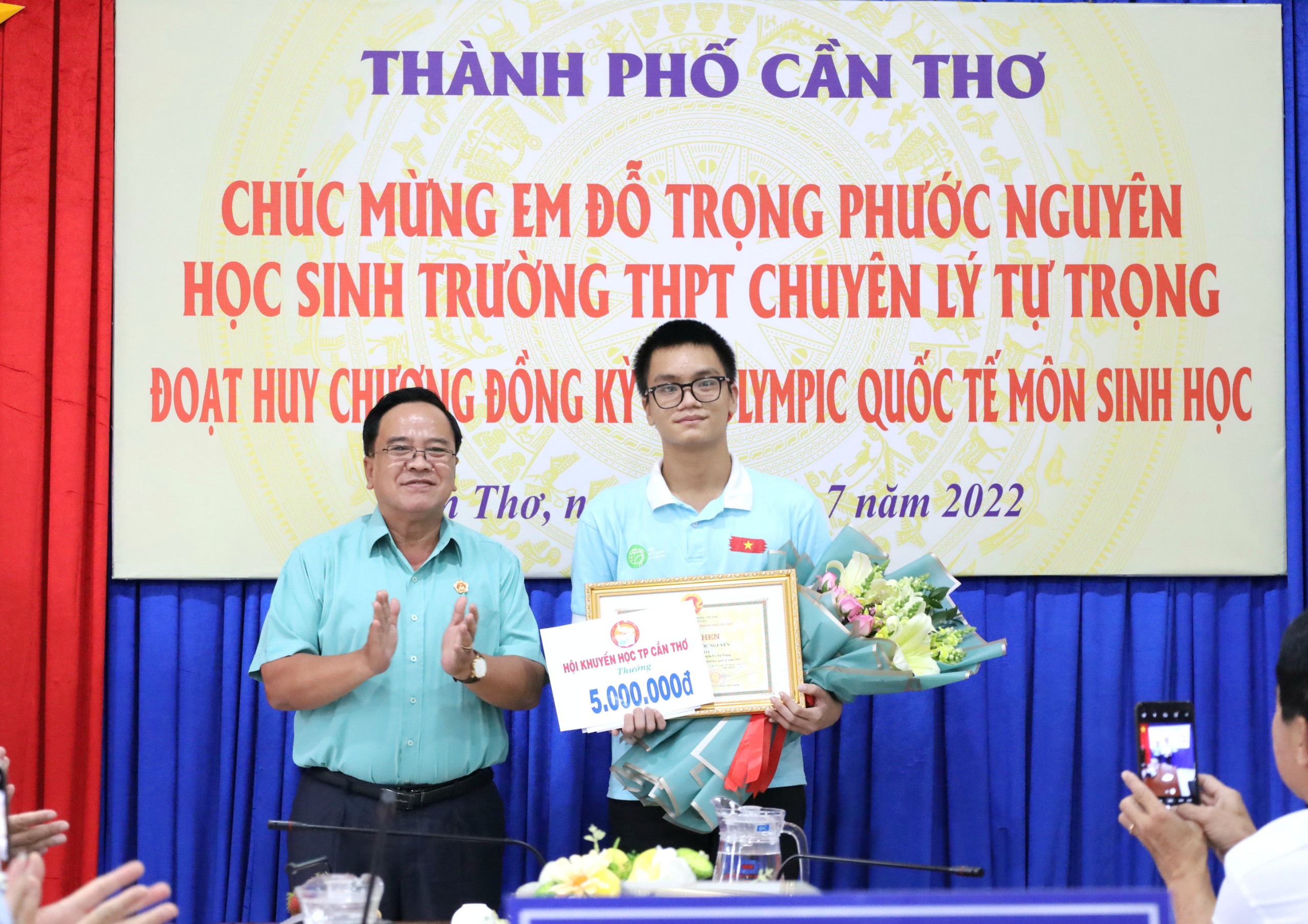 Ông Nguyễn Thanh Xuân - Chủ tịch Hội khuyến học TP. Cần Thơ trao quà cho em Đỗ Trọng Phước Nguyên.