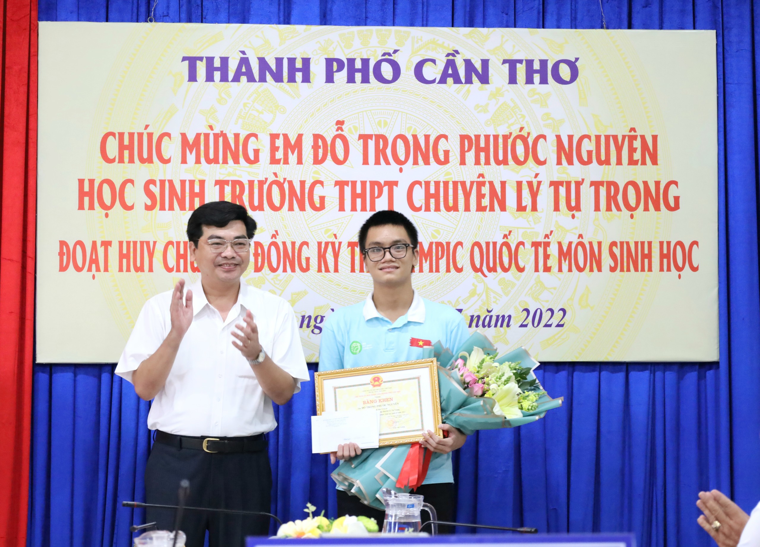 Ông Trần Thanh Bình - Giám đốc Sở Giáo dục và Đào tạo TP. Cần Thơ trao quà khen thưởng cho em Đỗ Trọng Phước Nguyên.
