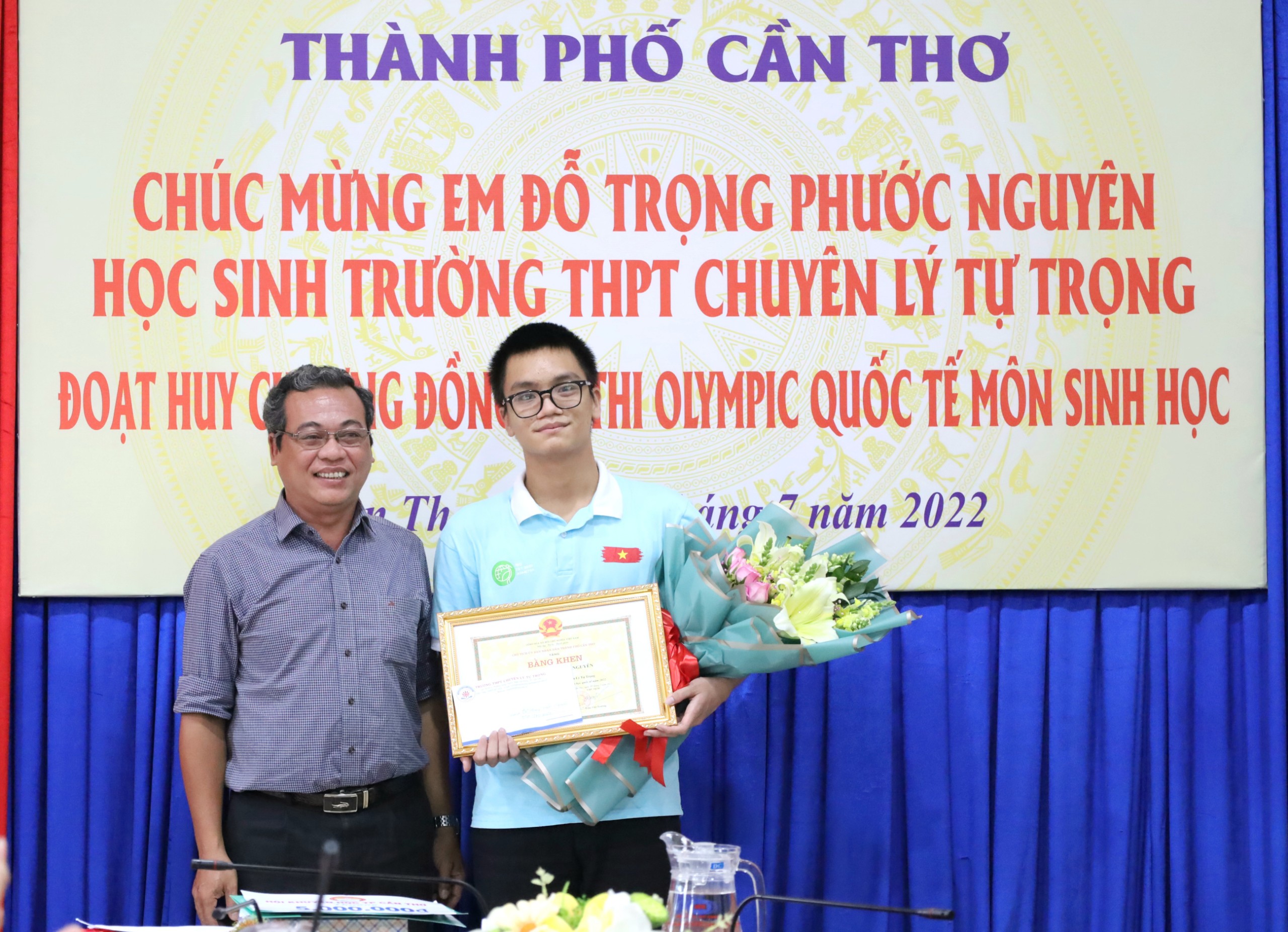 Ông Bùi Duy Minh Trí - Hiệu trưởng trường THPT chuyên Lý Tự Trọng trao thưởng cho em Đỗ Trọng Phước Nguyên.