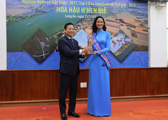 Phó Chủ tịch UBND tỉnh Long An Phạm Tấn Hòa trao biểu trưng và dải băng Đại sứ cho Hoa hậu H'hen Niê. Ảnh: longangov.