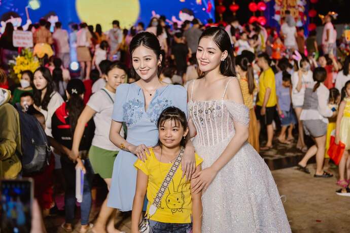 Hoa khôi Nam bộ 2017 Nguyễn Thị Hải Yến và Á hậu Đại dương 2017 Đặng Thanh Ngân chụp hình cùng em nhỏ tại Đêm hội.